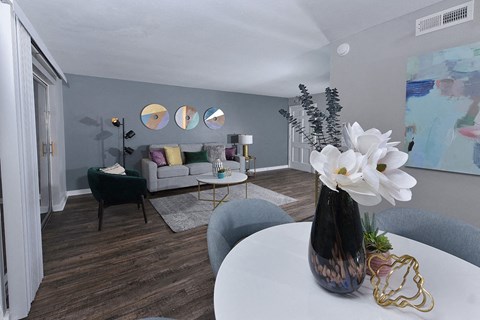 Open concept living room and dining area in Watermarc two-bedroom luxury apartment in lakeland, FL with wood tile flooring.
